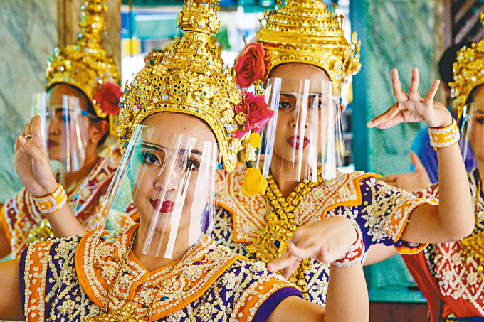 泰國傳統舞者三月在曼谷戴上防疫面罩跳舞。