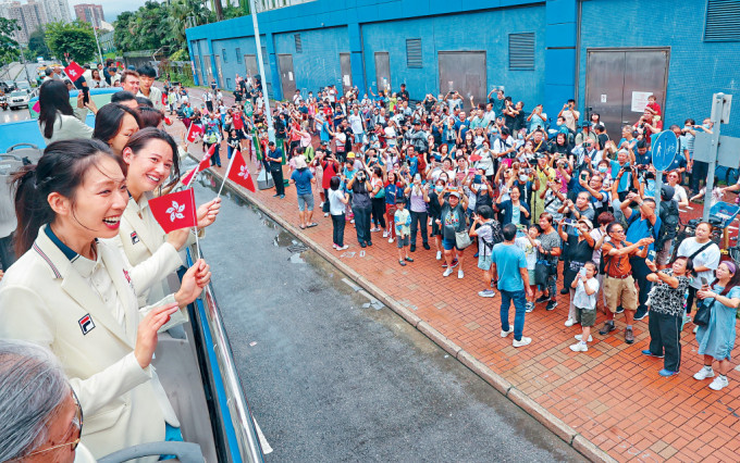 特区政府与港协暨奥委会昨日安排出战巴黎奥运的港将参与巴士巡游，「微笑剑后」江旻憓与「女飞鱼」何诗蓓大受市民欢迎。