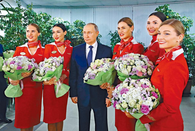 普京到访俄罗斯航空公司的培训中心，与美女机组人员合照，没有保持社交距离。  