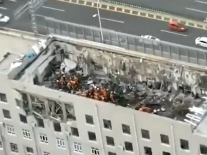 大樓頂層坍塌，導致11人被困。微博片段
