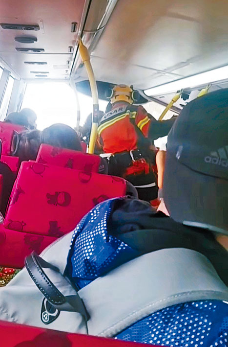 消防员进入巴士上层，将乘客逐一救出。