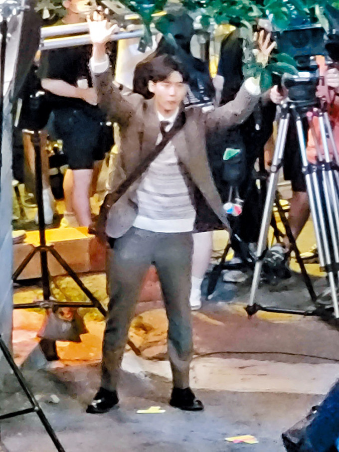 李鍾碩在街頭拍新劇，被網民拍到高舉雙手的鏡頭。