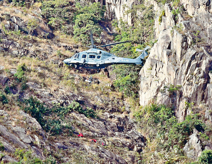 ■直升机将堕崖妇人的遗体吊起运走。