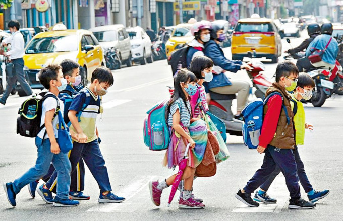 台北疫情升温，小学生戴上口罩。