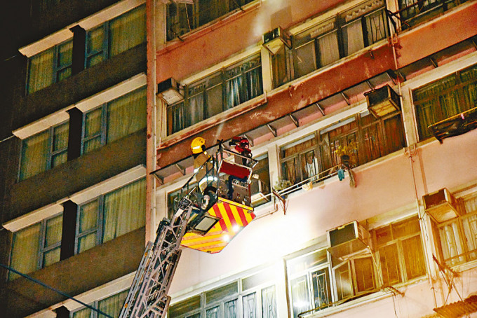 消防升起雲梯到起火劏房單位灌救，拯救被困住客。