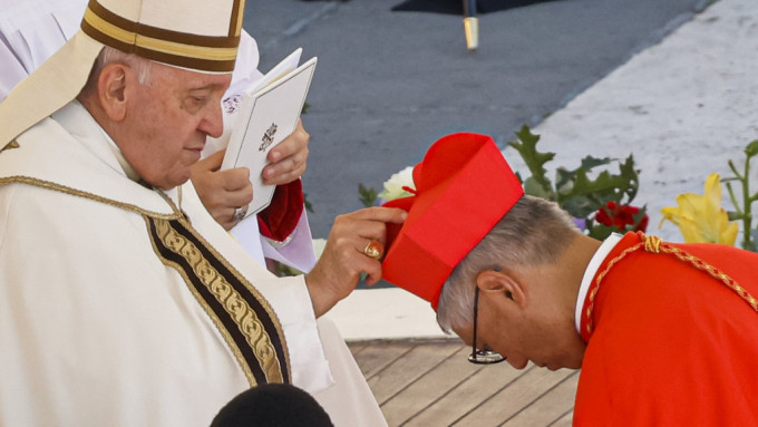 教宗方济各(左)主持枢机擢升仪式，为周守仁(右)戴上红帽。AP图片