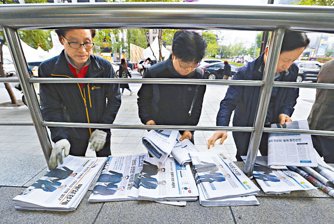南韓工人在首爾街頭整理出售的報章。 資料圖片
