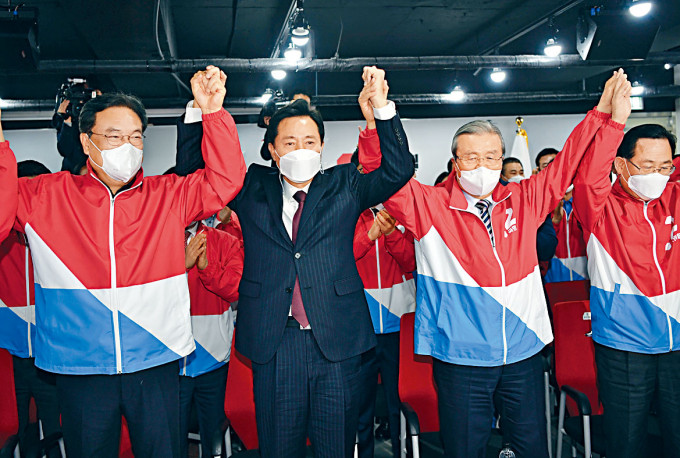 首爾市長候選人吳世勳(左二)與國民力量黨成員舉臂慶祝。