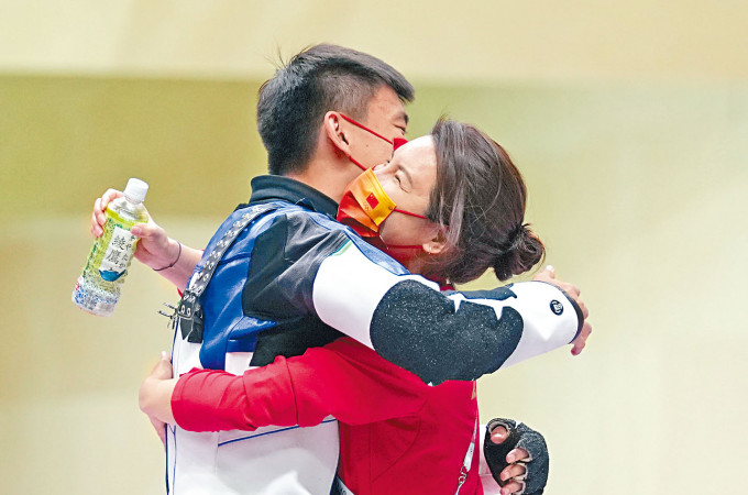■中國神槍手張常鴻（左）勝出後與教練杜麗擁抱。