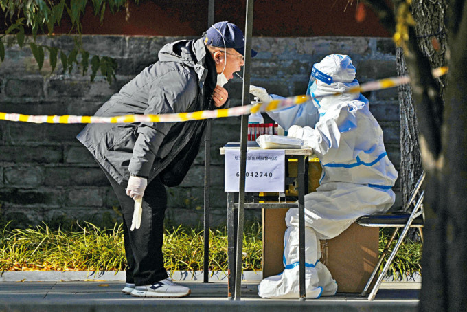 北京民众在街头采样站接受核酸检测。
