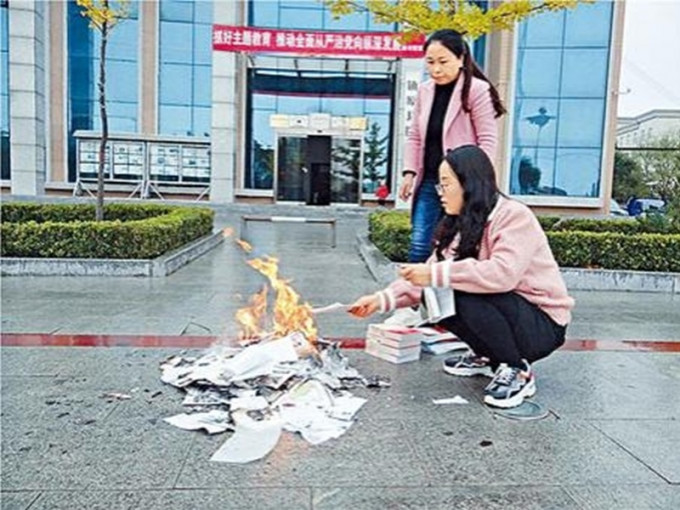 兩名女子在圖書館前將書籍撕碎焚毀。網圖