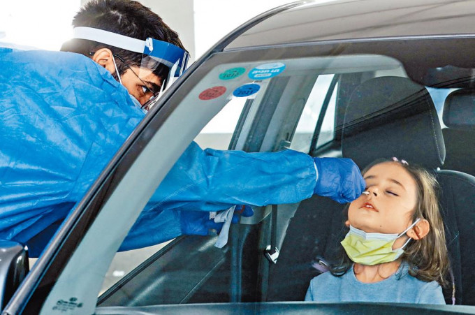 ■以色列醫護人員昨日在檢測地點，替一名乘汽車前來的兒童做測試。