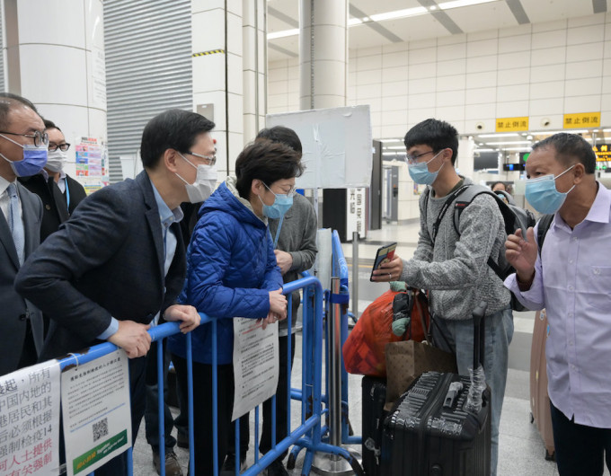 林郑月娥在深圳湾管制站与一对透过「回港易」计划返港的父子交谈。政府新闻处图片