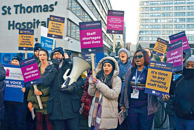 一批參加罷工的護士，昨日在倫敦聖托馬斯醫院門外集會。