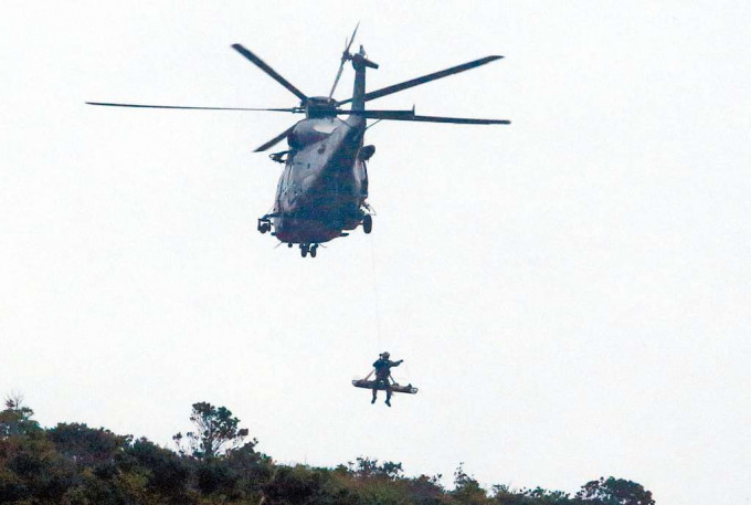 ■直升机将挂于树顶滑翔伞伤者救起。