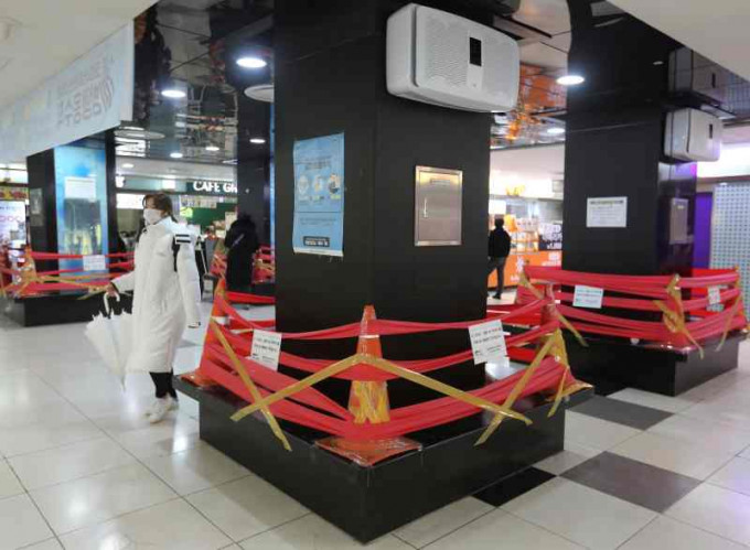 首爾商場內抗疫期間座位暫封，呼籲保持社交距離。AP