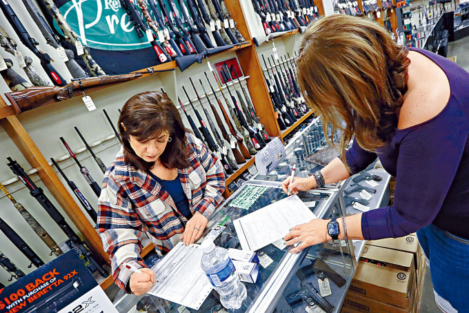 宾夕凡尼亚州一名女居民（左）在枪店填表买枪。