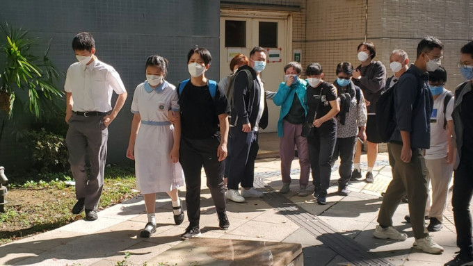 死者妻子（左七）及13岁女儿（左二）在亲友陪同下到殓房认尸。杨伟亨摄