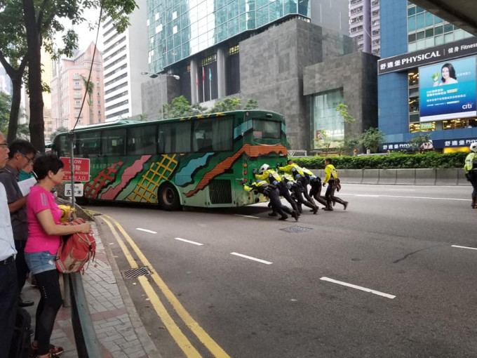 5名交通警員在旅遊巴車尾合力推車，試圖將旅遊巴推到路邊。網民Wing June‎/ fb群組香港突發事故報料區