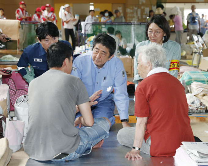安倍晋三（中）到冈山县慰问受难灾民。AP