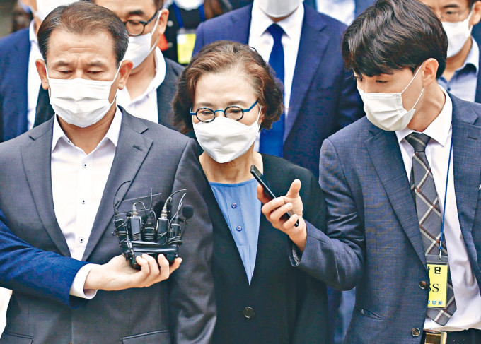 李明姬（中）周二在首爾中央地院聽判後離開法庭。