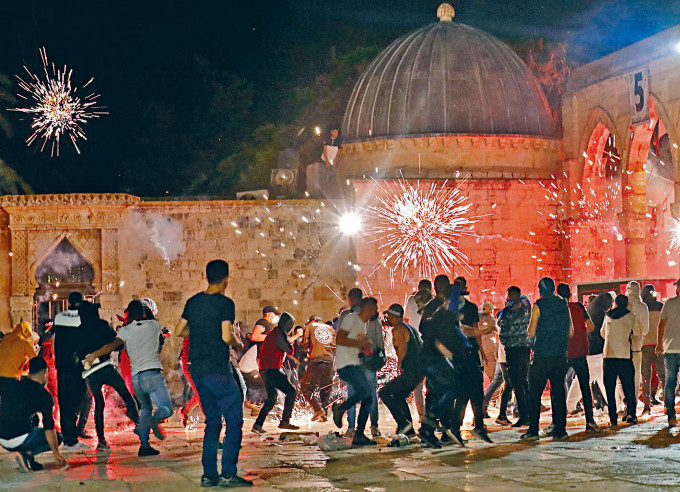 ■巴勒斯坦示威者与以色列警察在阿克萨清真寺爆发冲突，闪光弹在空中爆开。