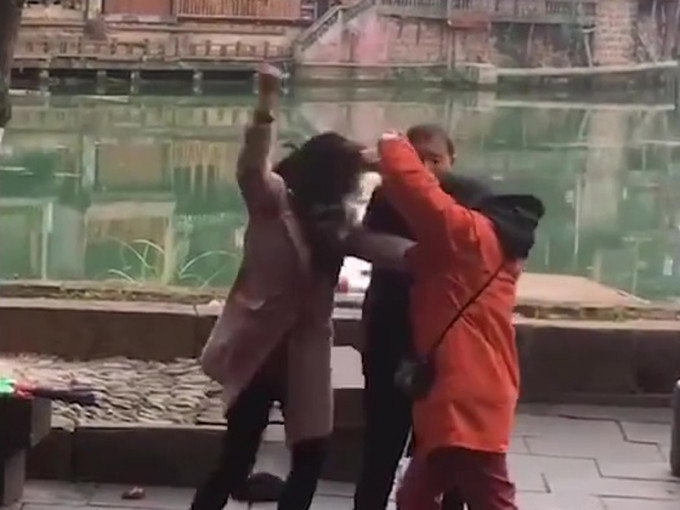 一男一女对穿橙衫的清洁工人殴打，男的箍颈、女的用藤条鞭打。(网图)