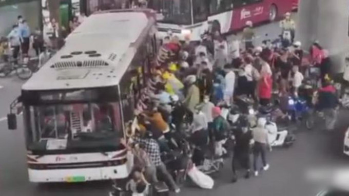 近百名群众立即上前试图抬起巴士救人。网图