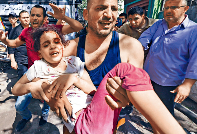 加沙一座大樓被摧毀，巴人在瓦礫中救出一個受傷女孩。
