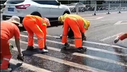 大连环卫工人在烈日下擦洗马路斑马线。