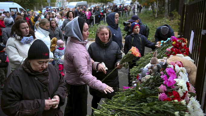 民众排队献花、放置玩具和点燃蜡烛，悼念校园枪击案的死者。AP