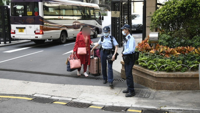 外佣最后拖行李离开，由警员带署调查。杨伟亨摄