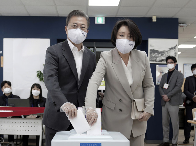 总统文在寅和夫人金正淑亦有戴上即弃式塑胶手套完成投票。 AP
