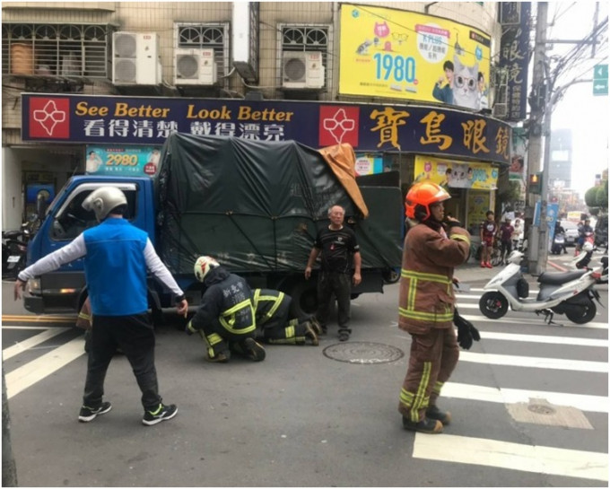 5名消防员合力将货车抬起救人。网图