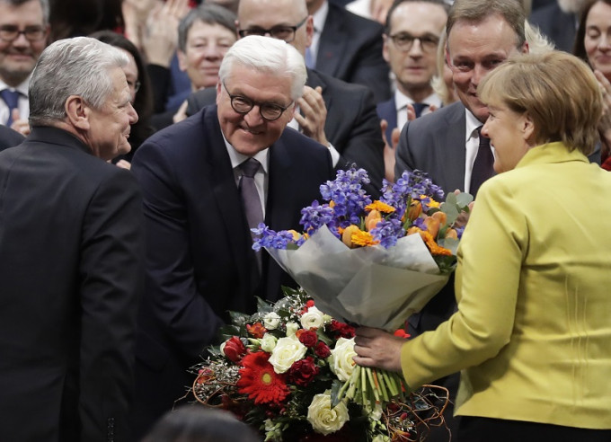 施泰因迈尔（左二）当选出任新总统后，获总理默克尔（右）献花。美联社