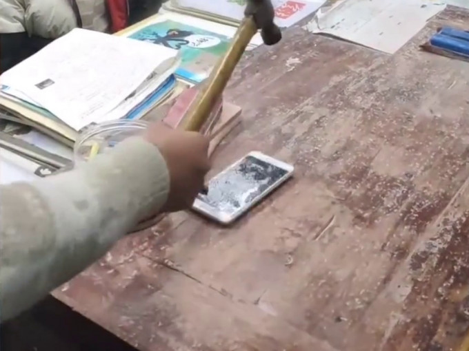 湖南老師為警示學生用錘砸自己不用的舊手機。