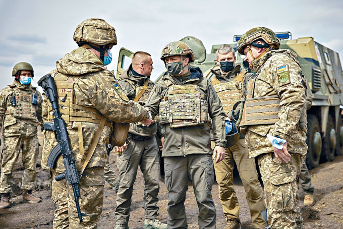 ■烏克蘭總統澤連斯基（中）周四到東部前綫視察，與士兵握手。