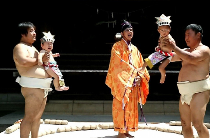 相撲手抱住嬰兒，人生第一次站在土俵裏。(網圖)