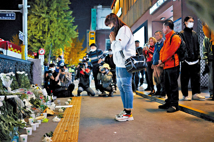 在梨泰院人踩人事故现场附近，有人摆放鲜花哀悼遇难者。
