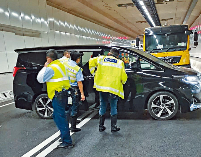 七人车驶进屯赤隧道堵路，警员采取拘捕行动。圆圈为司机。