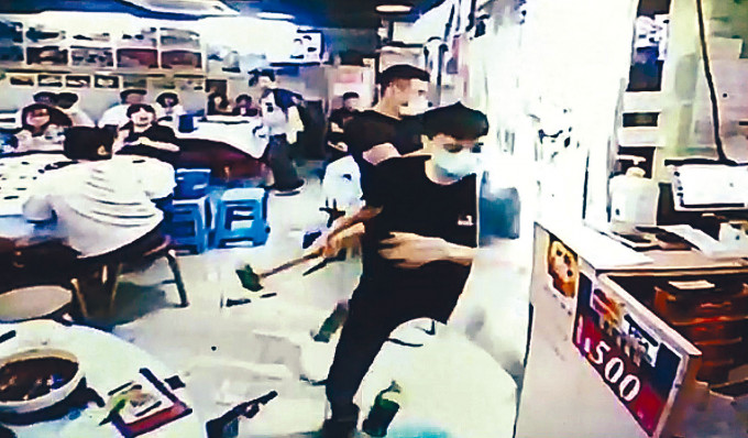 兩名戴口罩男子闖入海鮮飯店，以錘棍打爆魚缸。