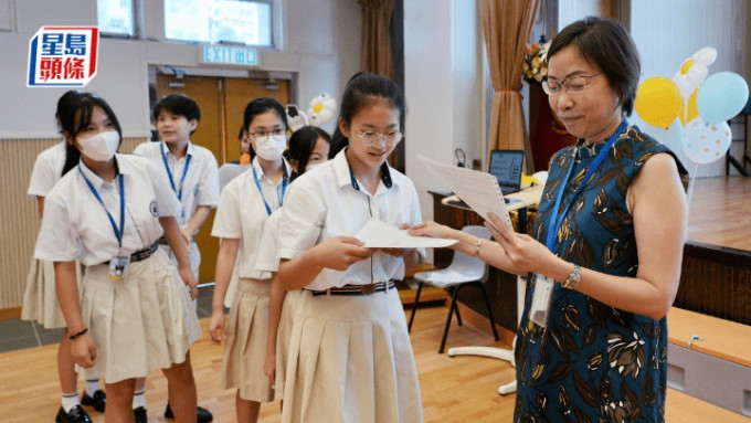 孔教学院大成小学昨迎来倒数第3个升中放榜日，校长潘淑娴（右1）亲自向学生派发「派位证」和「入学注册证」。欧乐年摄