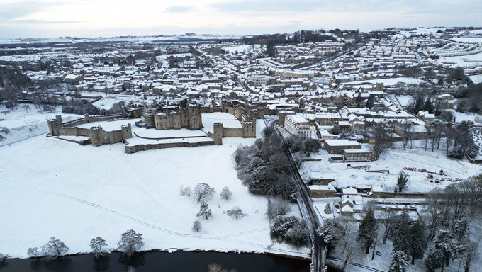 英国各地发布冰雪天气警告，英格兰东北部诺森伯兰郡的阿尼克城堡周围积雪覆盖的田野。AP
