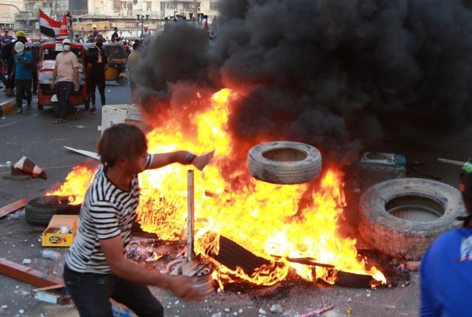 伊拉克首都巴格達，示威者在國營電視台總部附近集結，縱火焚燒雜物。AP