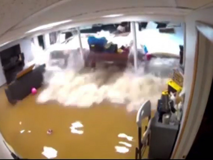 洪水冲破墙身，涌入地下室一刻。影片截图
