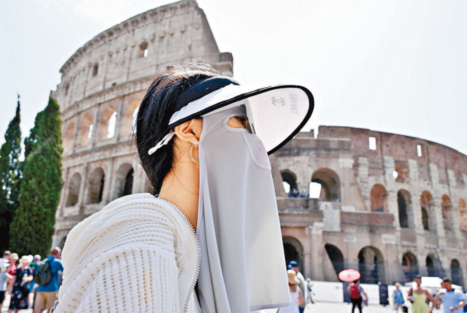 游客在罗马斗兽场外的防晒装扮。