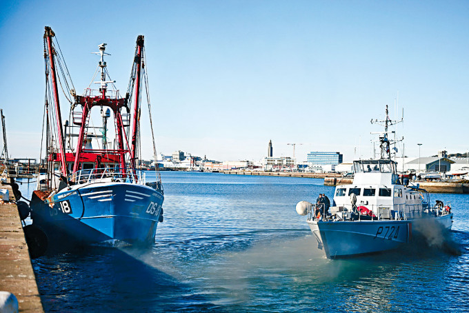 法国海警船（右）押送一艘被指非法捞捕的英国渔船到勒哈佛港。　