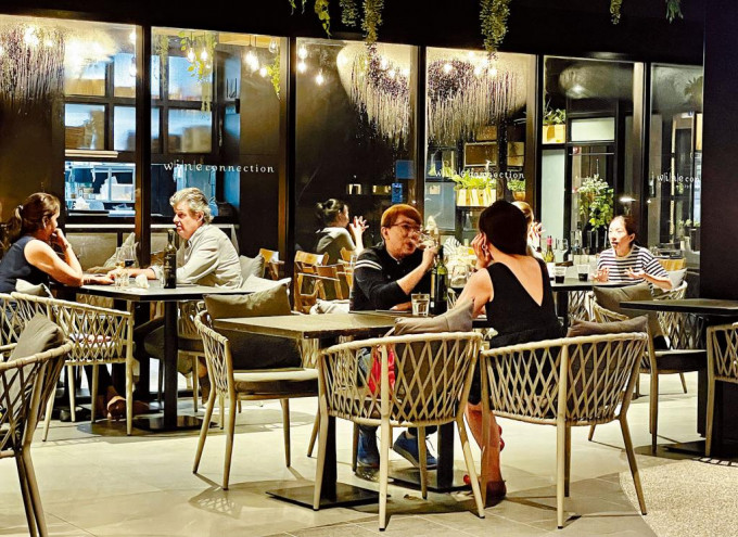 疫情趨穩的新加坡，周二起擴大鬆綁防疫措施；圖為當晚十時半後，客人在一家餐廳內飲酒。