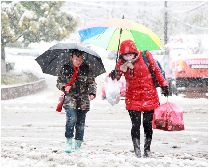 市民在江蘇南京街頭冒雪出行。 新華社