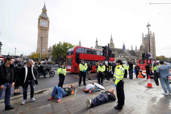 環保組織在倫敦街頭發起慢速遊行，並躺在地上，被指擾亂交通，有62人被捕。路透社